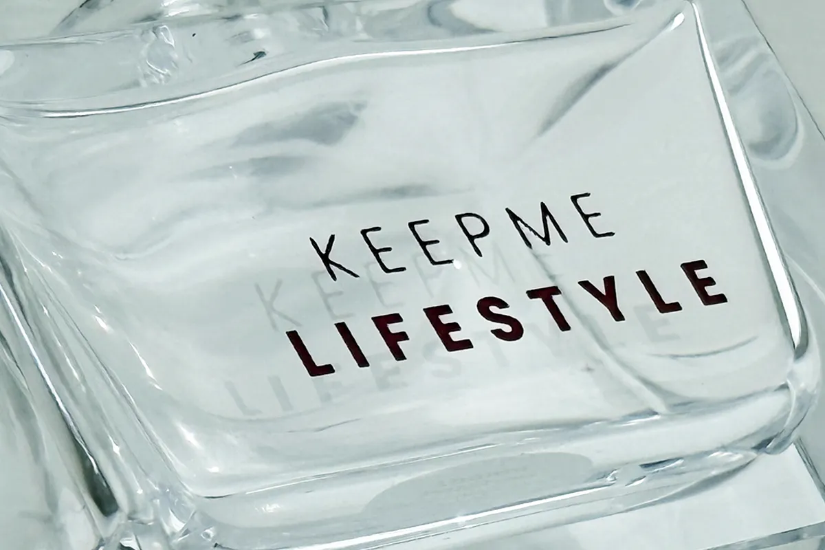 Polished clear glass fragrance bottle with KeepMe Lifestyle branding